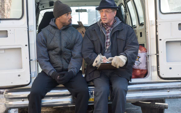 4K Ultra HD wallpaper featuring Sylvester Stallone as Rocky Balboa and Michael B. Jordan as Adonis Creed, sharing a moment from the movie Creed.