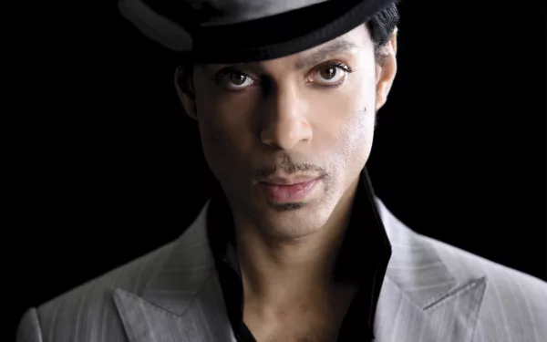 HD desktop wallpaper featuring American singer Prince wearing a hat, with a focused and intense expression against a black background.