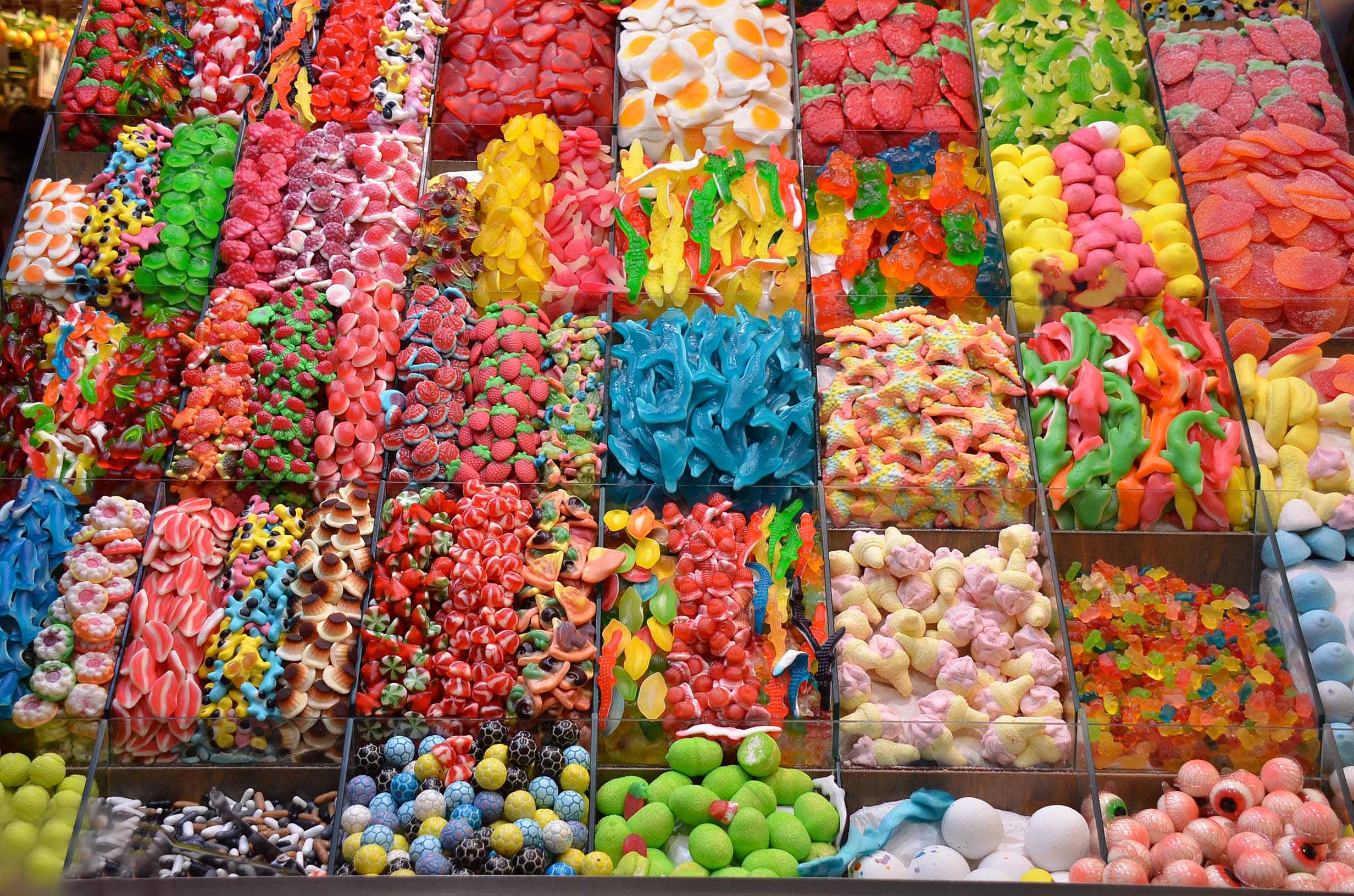 Confectionery display with a rainbow of colored lollies by pixelia