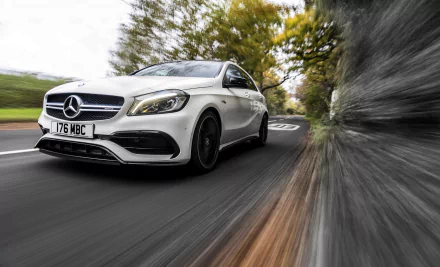White Mercedes‑Benz A‑Class compact car racing along a tree-lined road with dramatic motion blur — 4K Ultra HD PC desktop wallpaper background