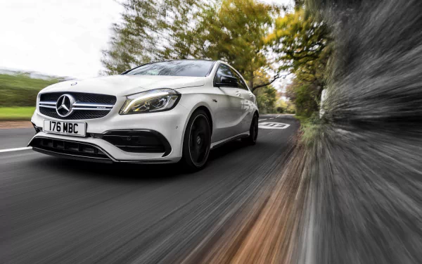 White Mercedes‑Benz A‑Class compact car racing along a tree-lined road with dramatic motion blur — 4K Ultra HD PC desktop wallpaper background