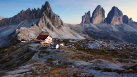 A snowy mountain landscape features a house and building in sharp focus with a tilt-shift effect, captured in clear HD photography for a PC desktop wallpaper.