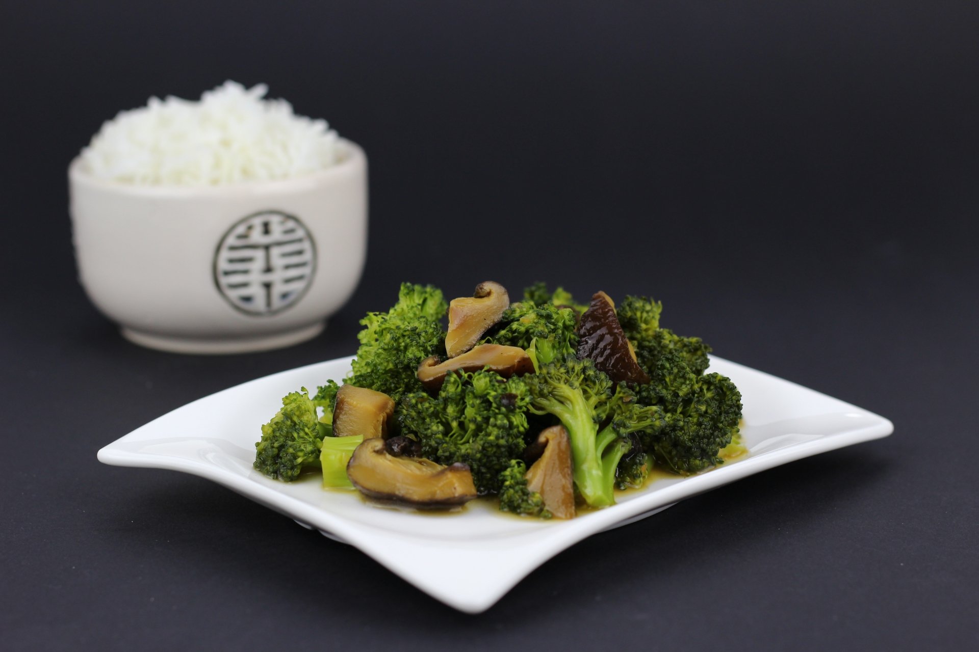 A 4K Ultra HD desktop wallpaper featuring a meal of sautéed broccoli and mushrooms on a white plate, with a bowl of white rice in the background.
