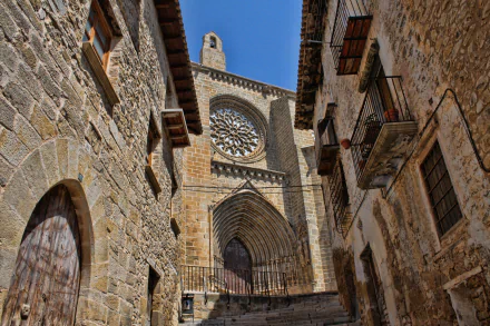 Gothic stone church and rose window framed by narrow medieval streets in Valderrobres, Spain — 4K Ultra HD PC desktop monument background.