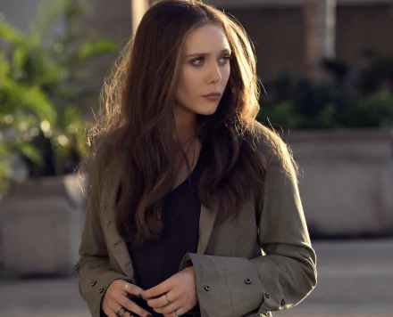 HD wallpaper featuring Wanda Maximoff (Scarlet Witch) with long brown hair, wearing a coat and ring, portrayed by Elizabeth Olsen in the movie Captain America: Civil War.