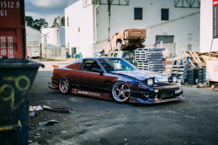 HD PC desktop wallpaper featuring a Nissan 180SX parked in an industrial setting, showcasing its sleek design and modified exterior.