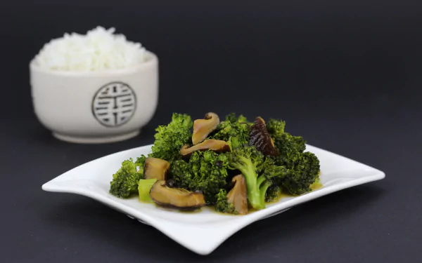 A 4K Ultra HD desktop wallpaper featuring a meal of sautéed broccoli and mushrooms on a white plate, with a bowl of white rice in the background.