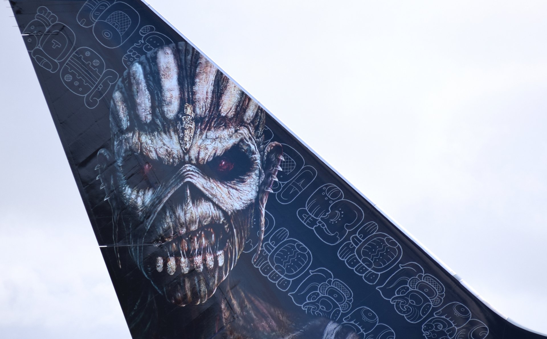 Airplane tail art showing Iron Maiden's Eddie snarling skull over repeating band logo — music-themed 4K Ultra HD PC desktop wallpaper and background.