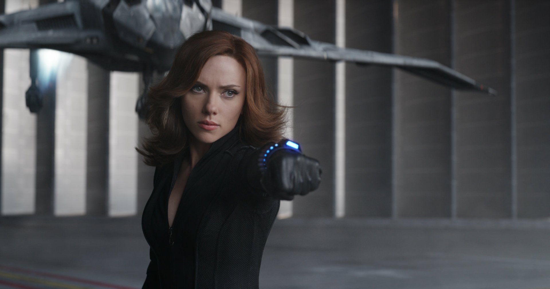 Scarlett Johansson as Black Widow in a dynamic pose from Captain America: Civil War, set against a sleek, futuristic background. An HD wallpaper capturing her fierce spirit.