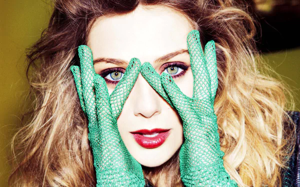 Elizabeth Olsen poses with striking green gloves, framing her face, showcasing her vibrant eyes and bold makeup in this high-definition desktop wallpaper and background.