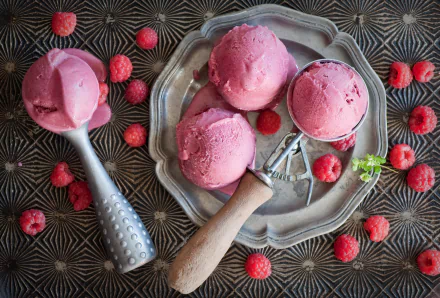 4K Ultra HD still life of vibrant raspberry ice cream scoops with fresh raspberries on an ornate surface, evoking a refreshing summer food moment.