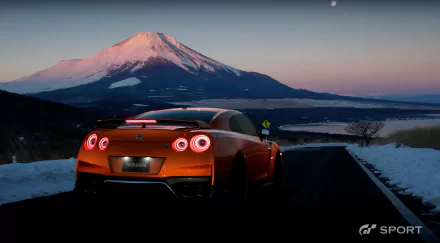 HD PC desktop wallpaper featuring a red sports car from Gran Turismo Sport driving on a road with Mount Fuji in the background at dusk.