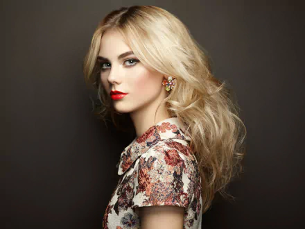 Portrait of a blonde woman wearing floral earrings and bold red lipstick, styled against a dark background, captured in high-definition photography.