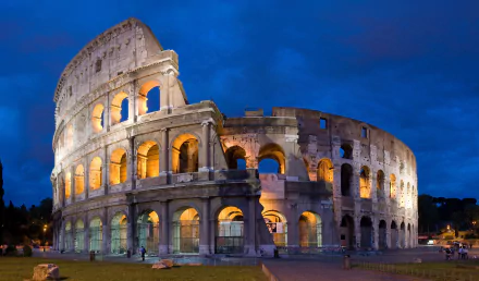 A stunning 4K Ultra HD wallpaper featuring the iconic Colosseum illuminated at dusk, showcasing its impressive architecture against a deep blue sky.