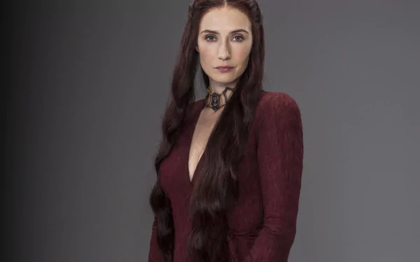Melisandre from Game of Thrones, portrayed by Carice van Houten, stands confidently in a deep red gown, showcasing her powerful and enigmatic presence in this 4K Ultra HD wallpaper.