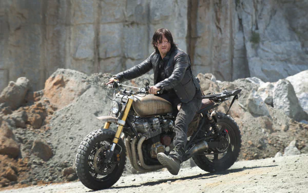 HD desktop wallpaper featuring Norman Reedus as Daryl Dixon from the TV show The Walking Dead. He is sitting on a motorcycle in a rugged, rocky landscape.