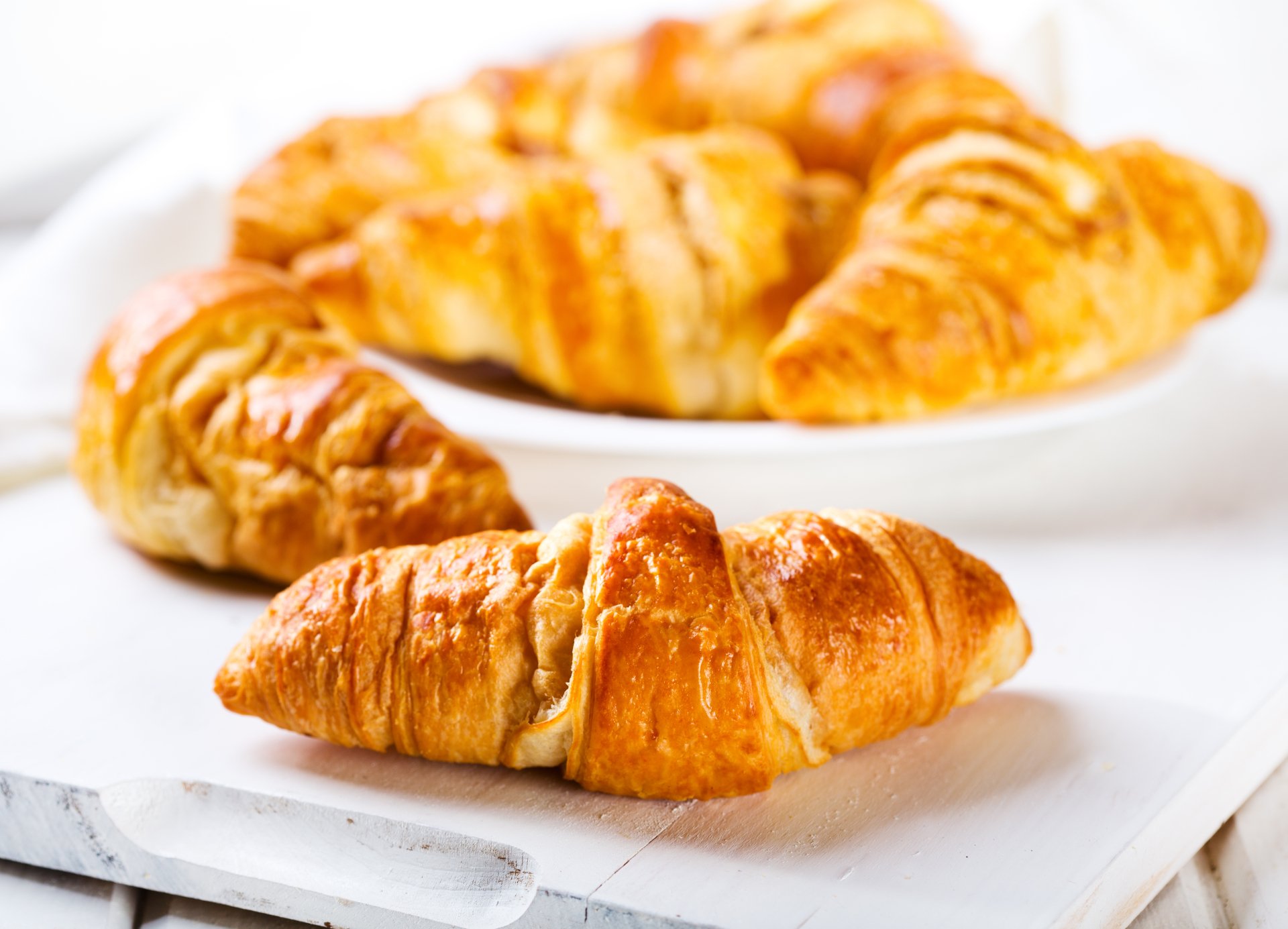 5K Ultra HD PC desktop wallpaper and background: golden croissants on white plates, breakfast food close-up.