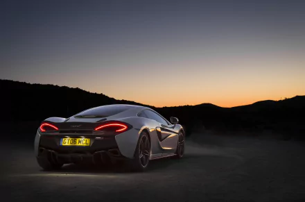 A sleek white McLaren 570GT supercar parked on a dark road at sunset, captured in stunning 4K Ultra HD as a high-resolution PC desktop wallpaper.