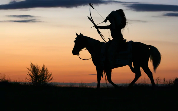 Silhouette of a Native American archer on horseback against a vibrant sunset, capturing the spirit of tradition and nature in this stunning 4K Ultra HD wallpaper.