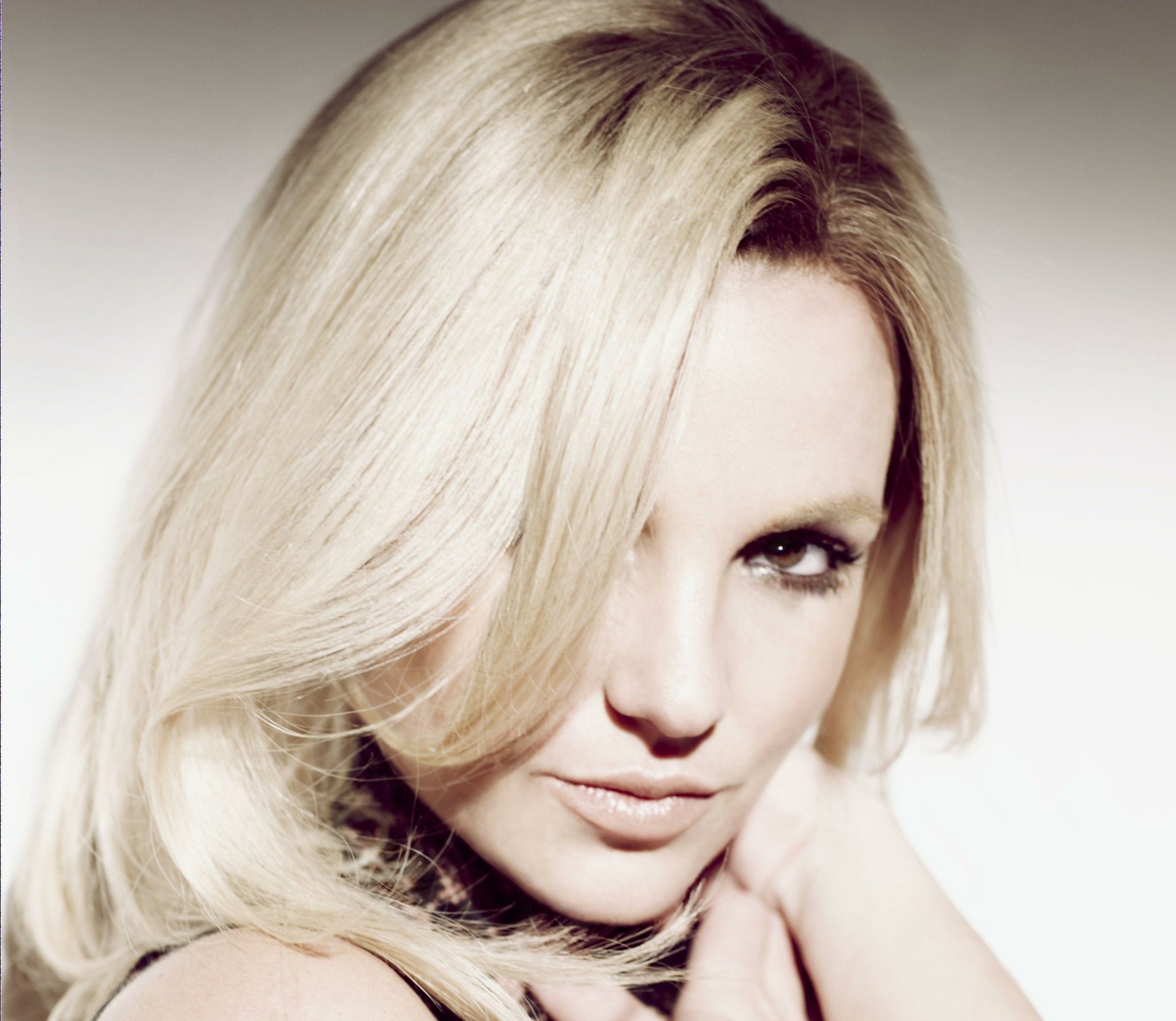 Close-up HD portrait of American singer Britney Spears with blonde hair and brown eyes, featured as a PC desktop wallpaper and background.
