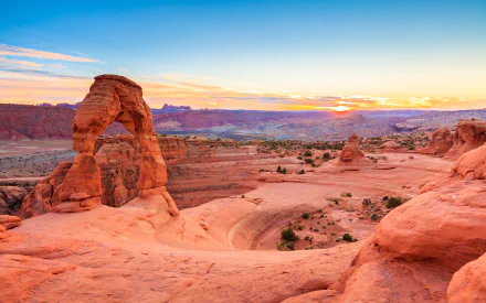 Sunset view of the iconic Delicate Arch and surrounding cliffs in Arches National Park, captured in stunning 4K Ultra HD landscape resolution.