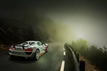 White Porsche 918 Spyder supercar driving on a misty mountain road, captured in high definition as a striking PC desktop wallpaper.