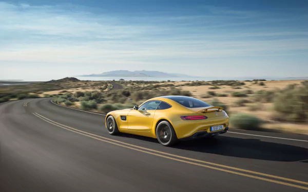 Yellow Mercedes‑Benz AMG GT supercar speeding on a desert highway — HD PC desktop wallpaper background featuring the Mercedes‑Benz AMG vehicle.