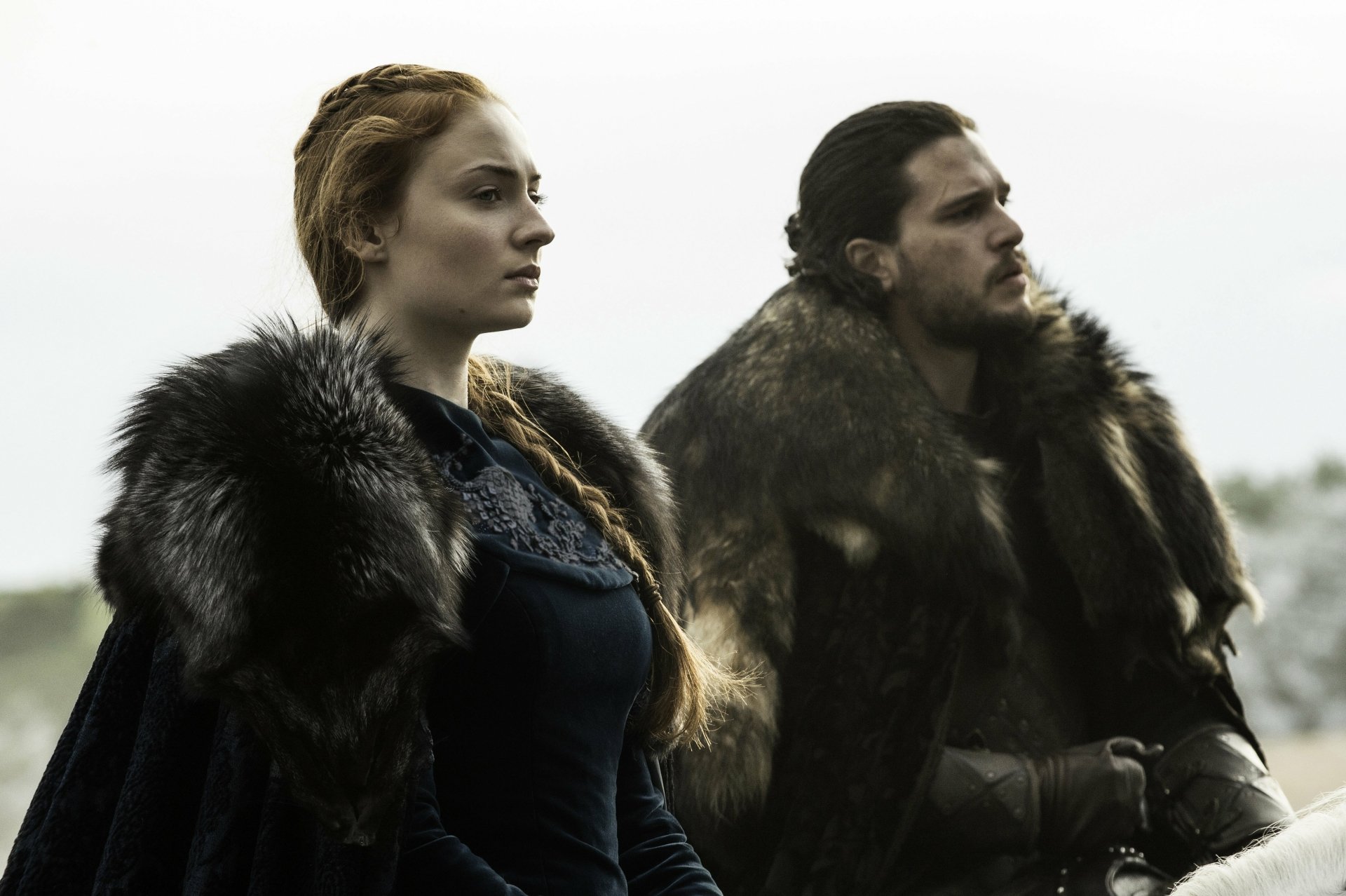 Jon Snow and Sansa Stark, portrayed by Kit Harington and Sophie Turner, stand together in this dramatic HD wallpaper from Game of Thrones, dressed in fur cloaks against a misty backdrop.