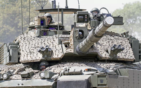 HD desktop wallpaper featuring a close-up view of a military Challenger 2 tank with soldiers visible inside, showcasing its detailed armored exterior and main cannon.