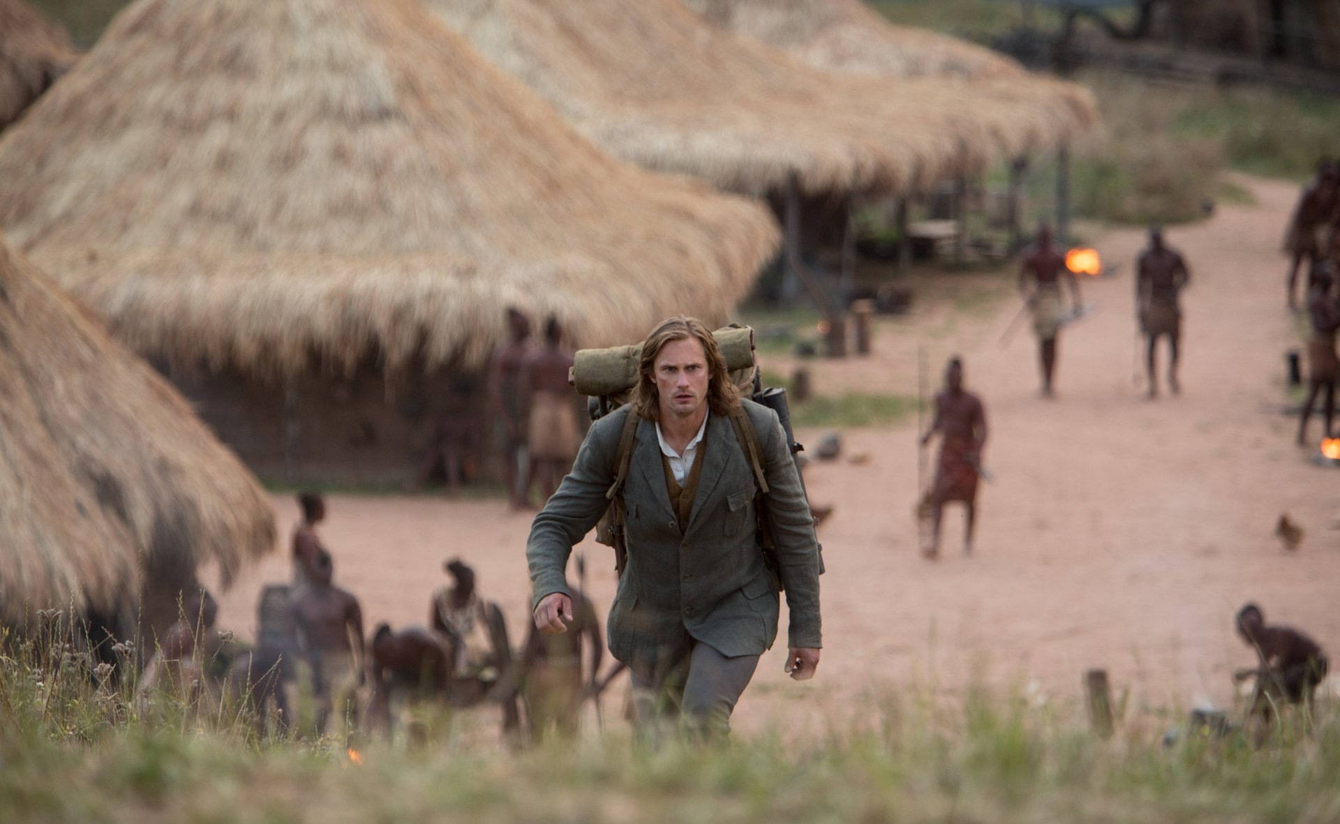 Tarzan from The Legend of Tarzan movie walks through a village scene, cinematic 5K Ultra HD PC desktop wallpaper/background.