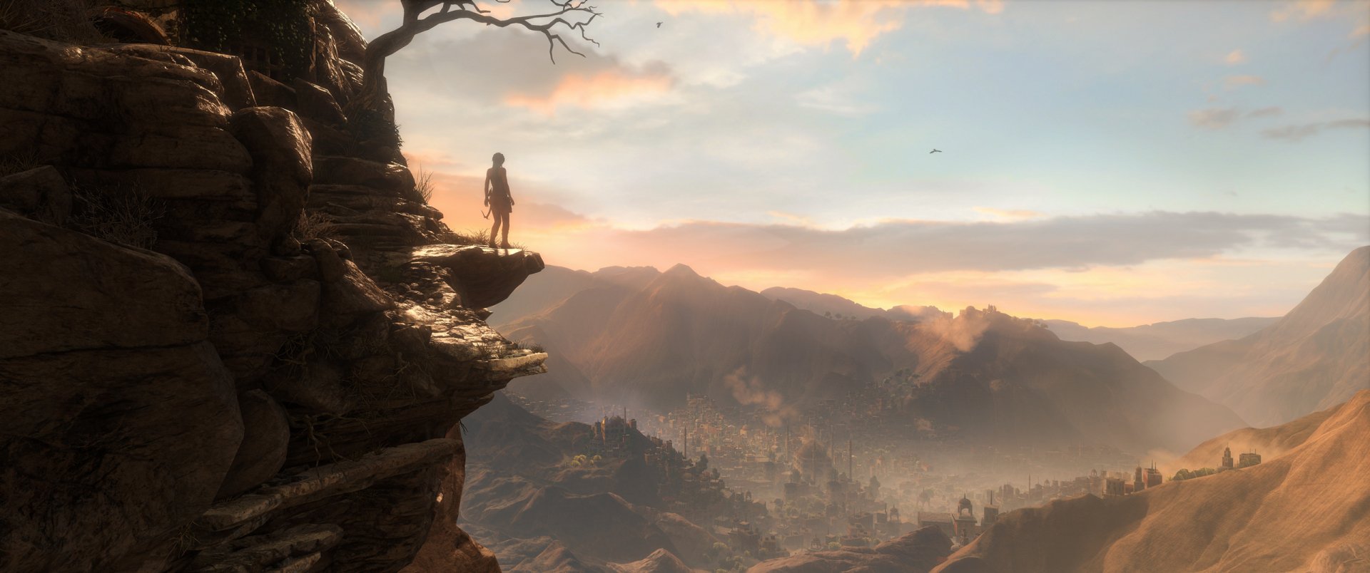 A stunning HD wallpaper from Rise of the Tomb Raider, featuring a lone figure standing on a cliff, gazing across a vast mountainous landscape at sunset.