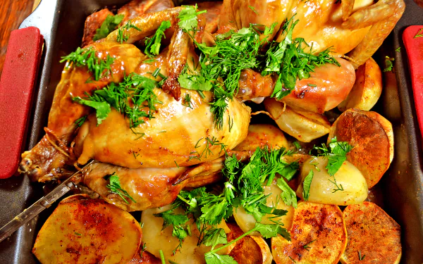 4K Ultra HD wallpaper showing a roasted chicken garnished with fresh herbs, surrounded by golden potato slices in a baking dish.