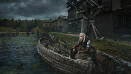 HD PC desktop wallpaper featuring a man cosplaying Geralt of Rivia from The Witcher, sitting on a wooden boat by a lakeside village under a cloudy sky.