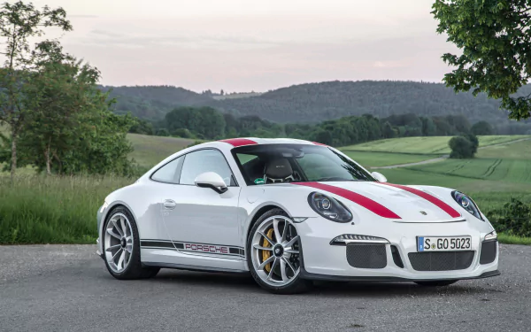 A sleek white Porsche 911 Turbo parked on a scenic road, showcasing its sporty design against a backdrop of green hills and trees, captured in stunning 4K Ultra HD.