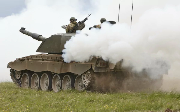 HD desktop wallpaper showing a Challenger 2 military tank emitting thick smoke with soldiers positioned on top in an open grassy field.