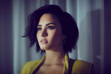 Demi Lovato, an American singer with brunette hair and brown eyes, gazes thoughtfully in this high-definition wallpaper, showcasing her captivating presence in the music scene.