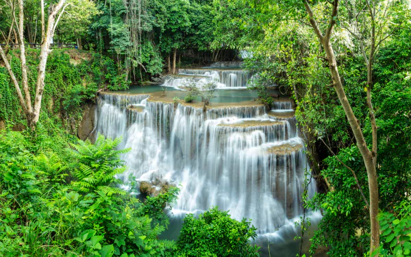 Erawan Waterfall at Huai Mae Kamin in Thailand's national park, captured in stunning 4K Ultra HD, surrounded by lush green forest and cascading water layers.