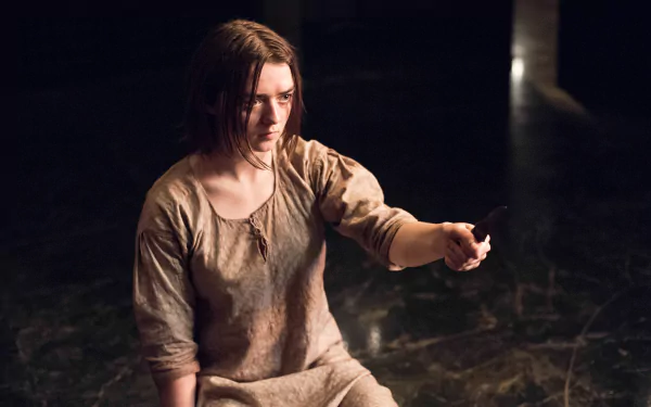 Maisie Williams as Arya Stark from Game of Thrones, depicted in a dimly lit scene, featured in a 4K Ultra HD PC desktop wallpaper and background.
