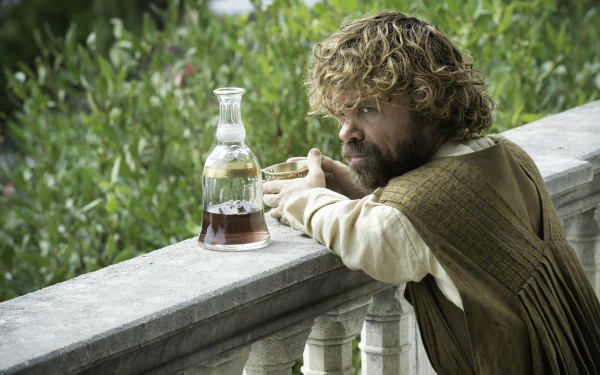 Tyrion Lannister, portrayed by Peter Dinklage in Game of Thrones, leans on a stone balcony next to a glass decanter, captured in 4K Ultra HD wallpaper quality.