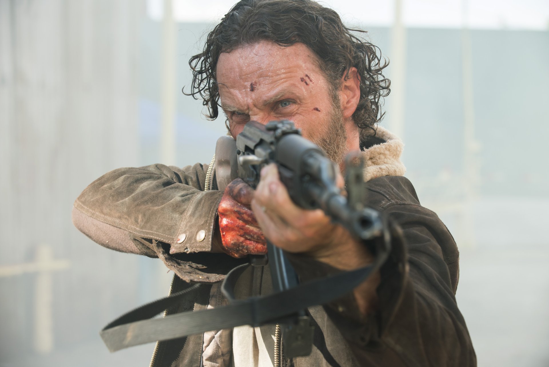 Rick Grimes, portrayed by Andrew Lincoln, aims a weapon in this intense scene from The Walking Dead, showcasing the gripping drama of the acclaimed TV show. HD PC desktop wallpaper.