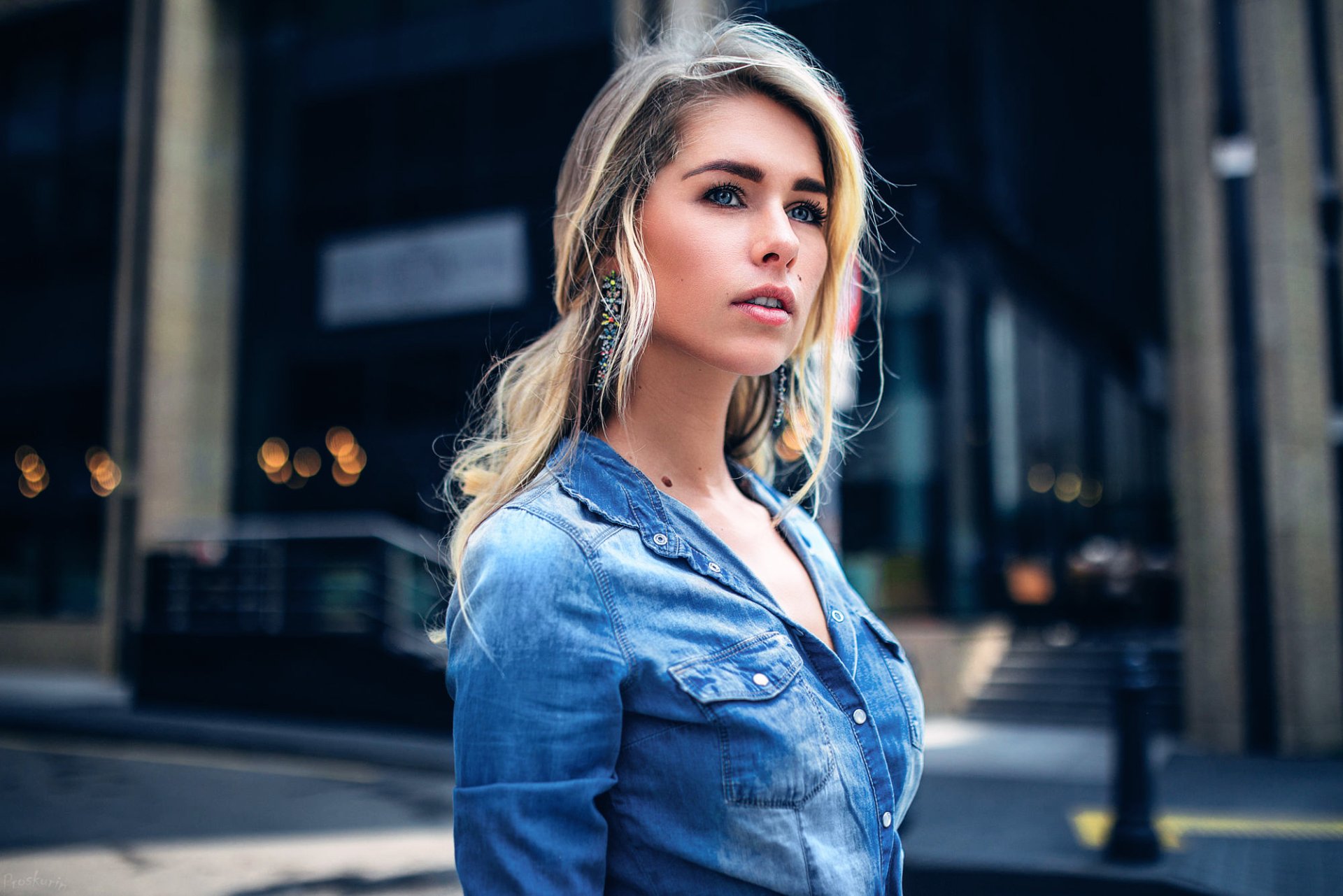 Blonde woman model with blue eyes wearing earrings, dressed in a denim shirt, captured outdoors in HD for a desktop wallpaper background.