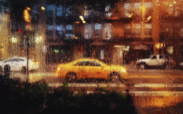 HD desktop wallpaper showing a rainy street scene through a window with raindrops, featuring blurred cars and city lights in vibrant colors.