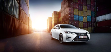 White Lexus ES sedan parked between stacked shipping containers at sunrise, presented as a 2K Quad HD PC desktop wallpaper and background.