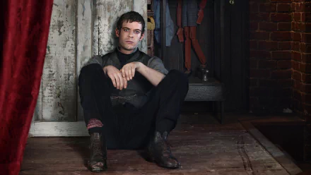 A character from the TV show Penny Dreadful sits against a wall, reflecting a moody atmosphere. This HD desktop wallpaper captures the show's dark aesthetic and emotional depth.