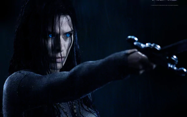 HD PC desktop wallpaper from the movie Underworld: Rise of the Lycans, featuring a dark, intense character with glowing blue eyes aiming a weapon.