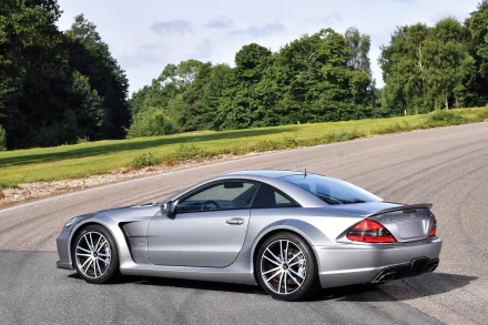 Silver Mercedes-Benz SL-Class grand tourer parked on a curved road with lush green trees in the background, captured in 4K Ultra HD for PC desktop wallpaper.