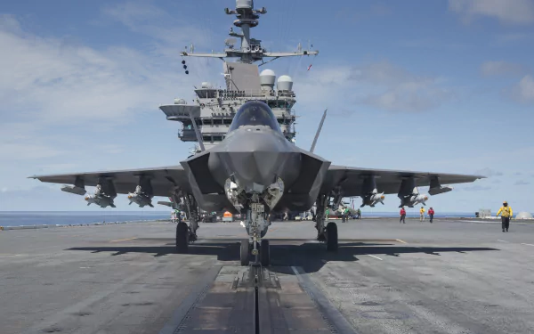 A Lockheed Martin F-35 Lightning II jet fighter positioned on the deck of an aircraft carrier, showcasing its sleek design against a clear sky backdrop.