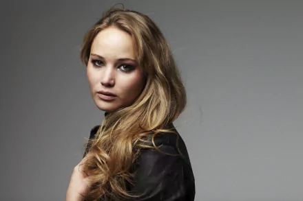 A striking 4K Ultra HD wallpaper featuring celebrity Jennifer Lawrence, showcasing her with flowing hair and an expressive gaze against a neutral background.