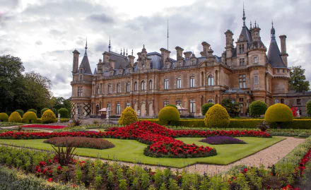 A stunning view of Waddesdon Manor, an impressive palace set amidst vibrant gardens, showcasing meticulous landscaping and intricate architecture in England.
