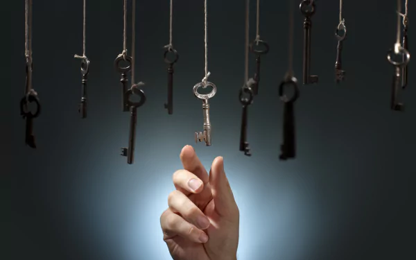 A hand reaches toward hanging man-made keys against a dark background, designed as a 4K Ultra HD PC desktop wallpaper and background.